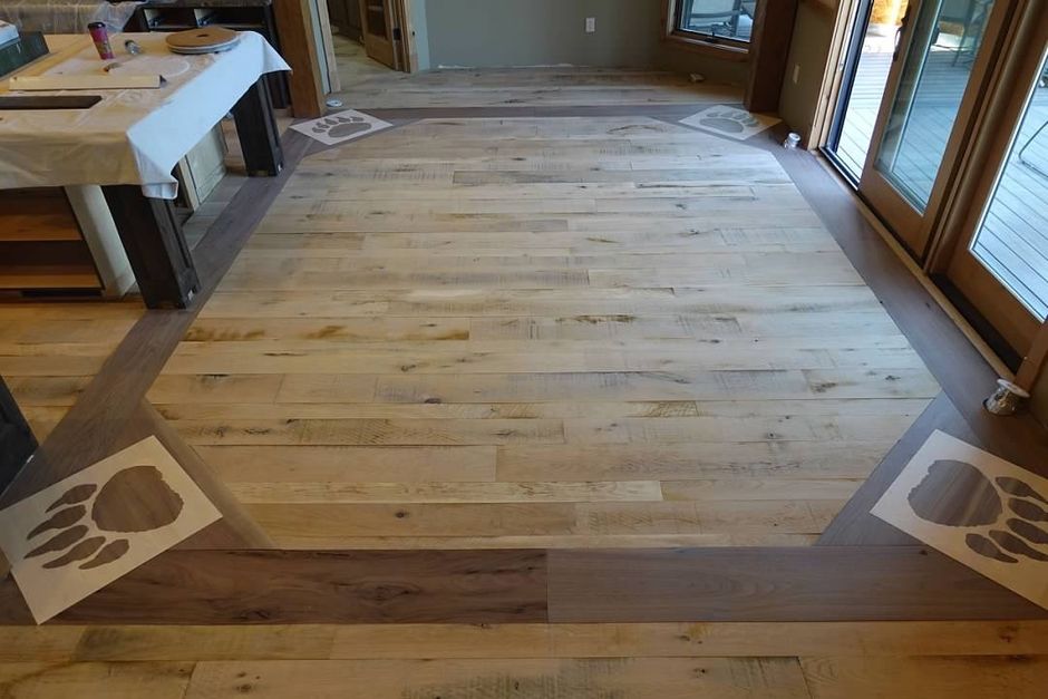 A wooden floor in a room with a table in the background