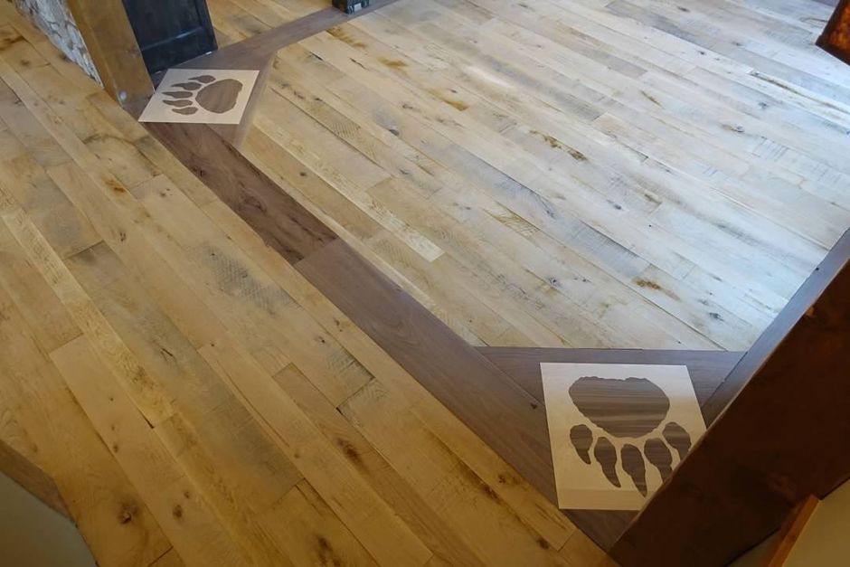 A wooden floor with a bear paw print on it