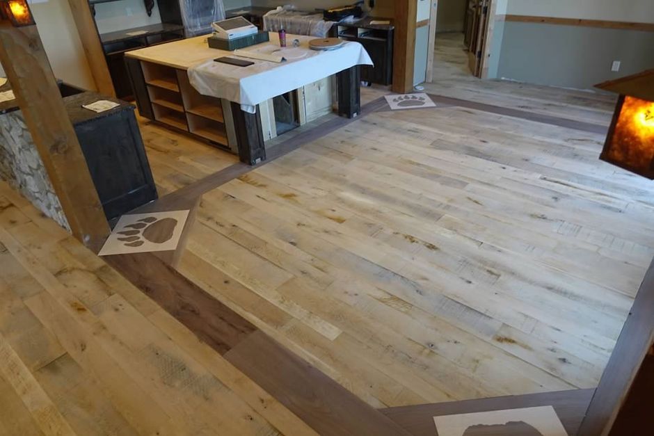 A wooden floor in a room with a table in the background.