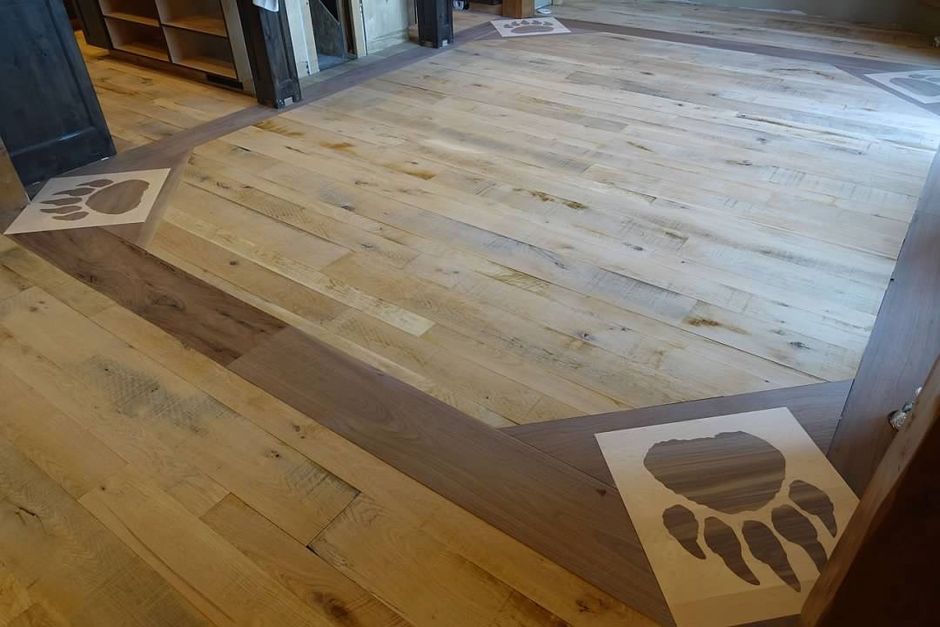 A wooden floor with a stencil of a bear paw on it