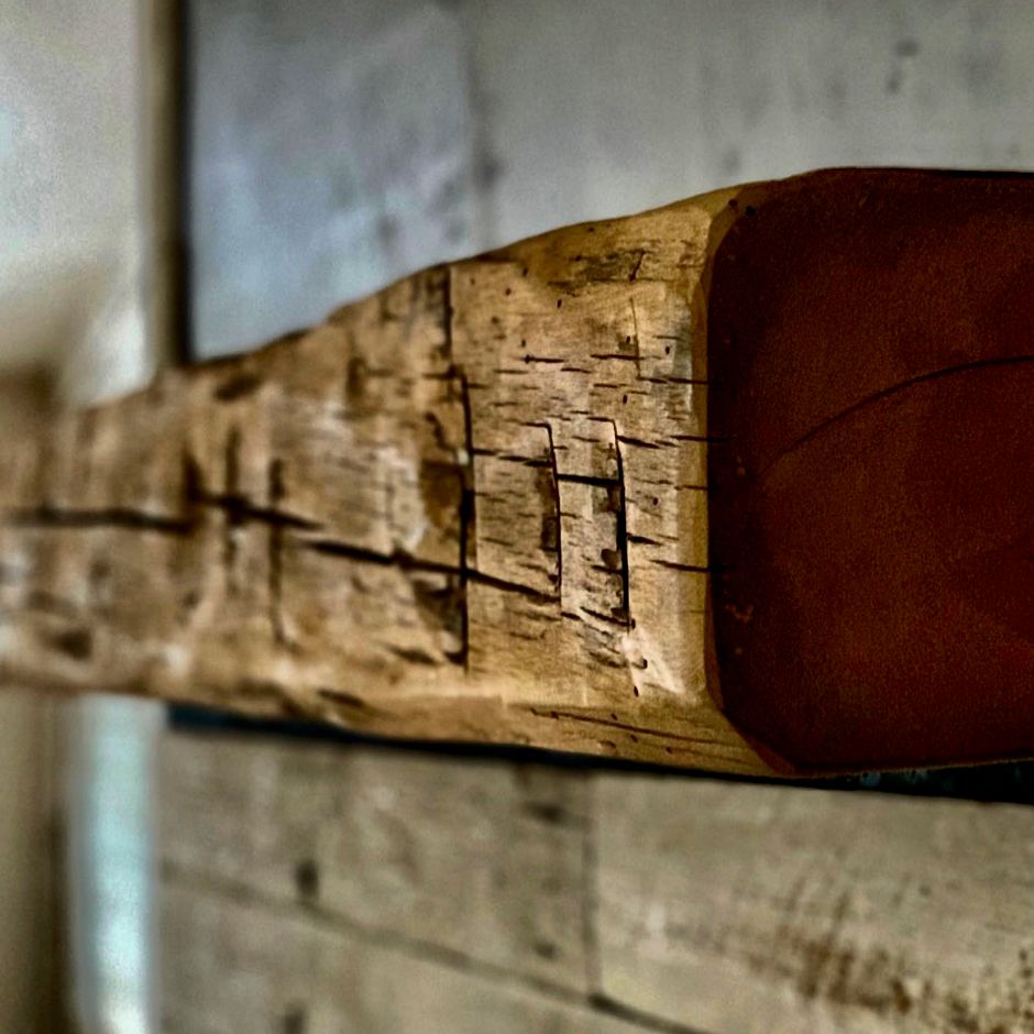 A large piece of wood is hanging on a wall