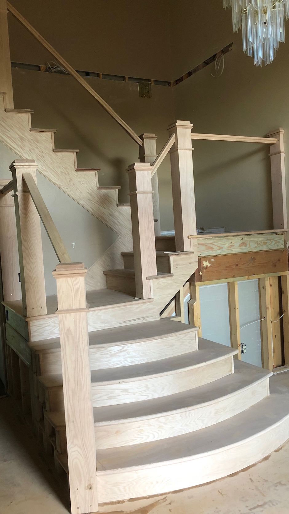 A wooden staircase is being built in a house.