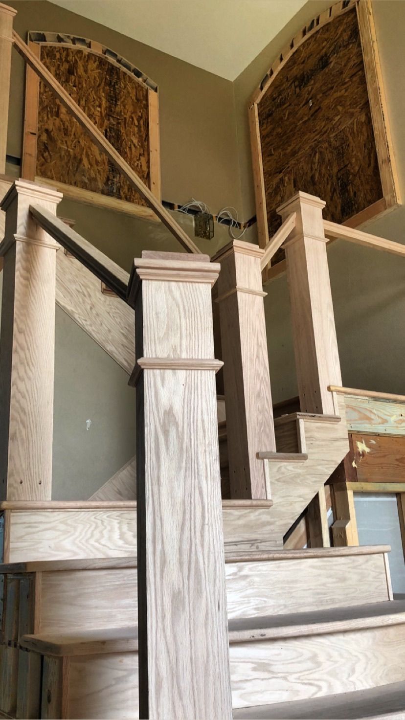 A wooden staircase is being built in a house.