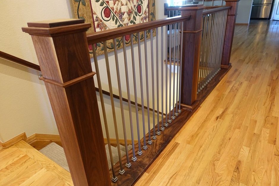 A wooden staircase with a metal railing in a house.