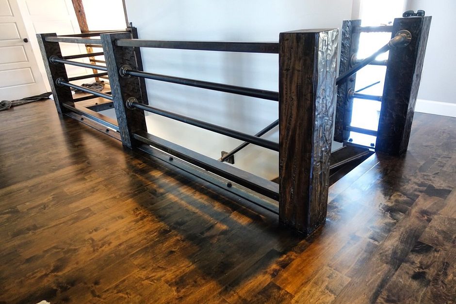 A wooden staircase with a metal railing and a wooden floor.