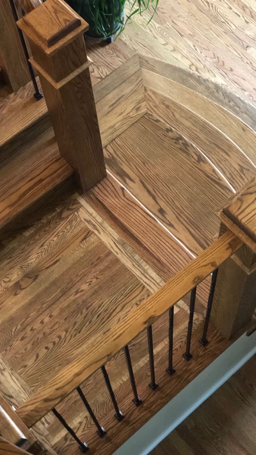 A wooden staircase with a wooden railing and a wooden floor.