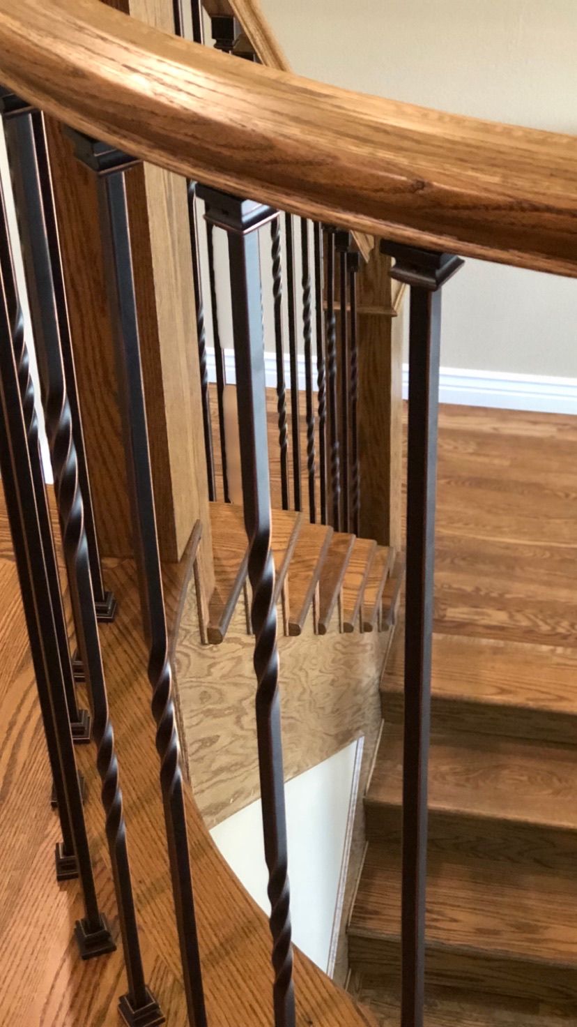 A close up of a wooden staircase with a metal railing.