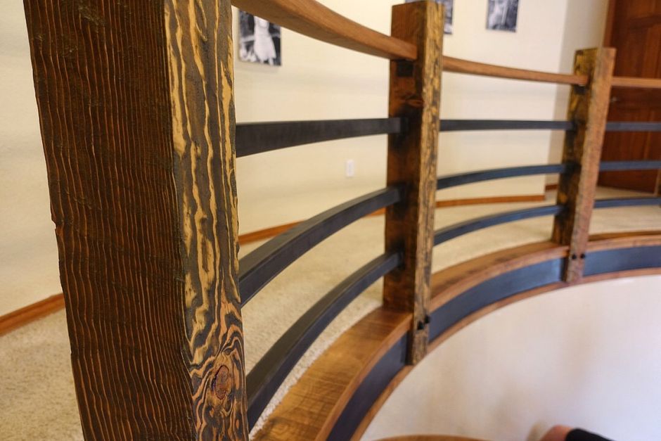 A close up of a wooden railing on a spiral staircase