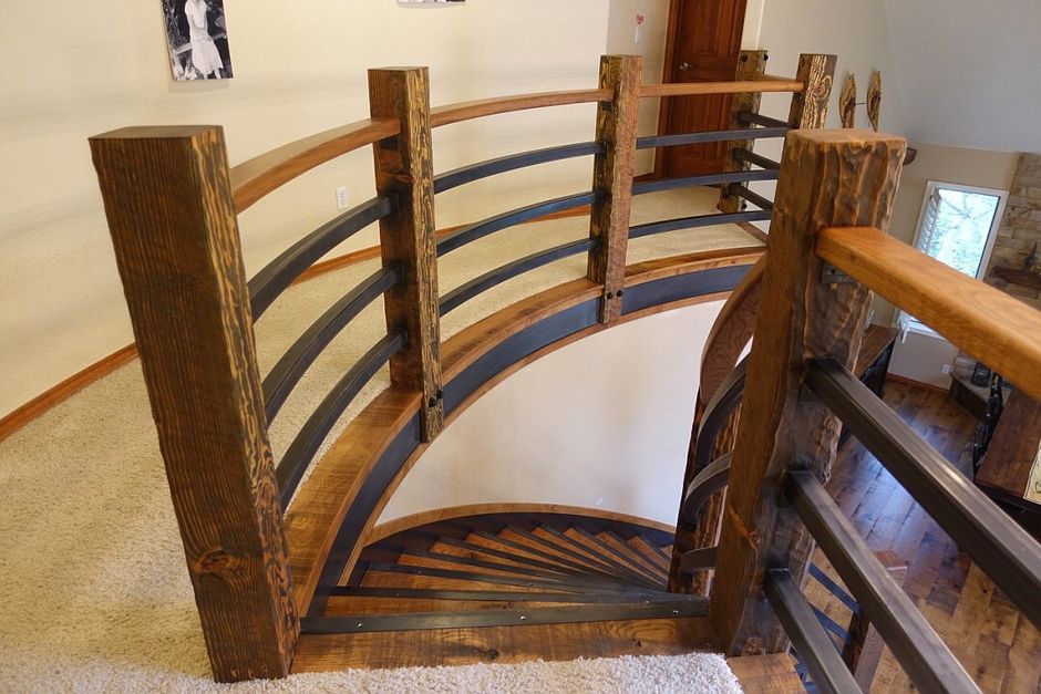 A wooden spiral staircase with a metal railing