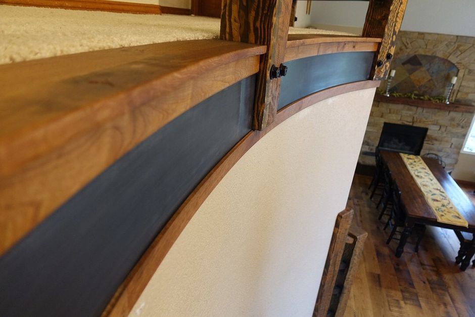 A wooden staircase leading up to a living room with a table and chairs.