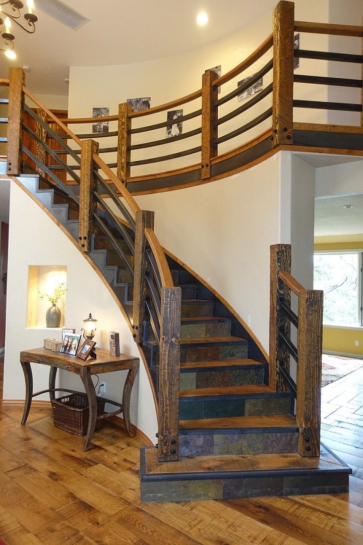 A curved staircase with a wooden railing in a house.