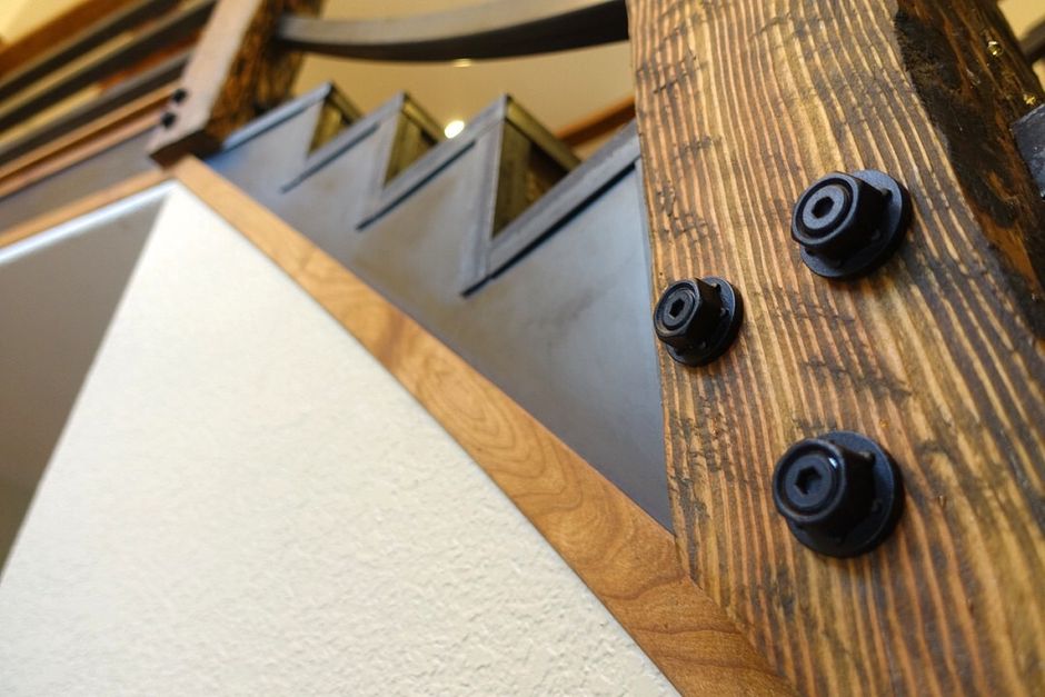 A close up of a wooden staircase with a metal railing