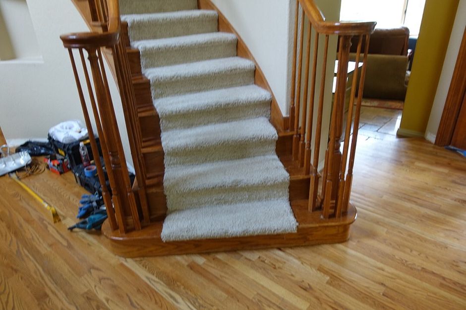 A staircase with a carpeted staircase and wooden railing in a living room.