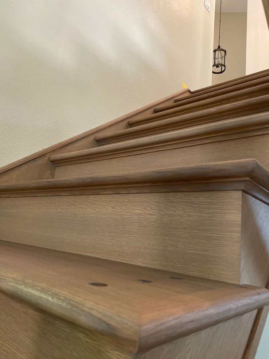 A close up of a wooden staircase in a house.