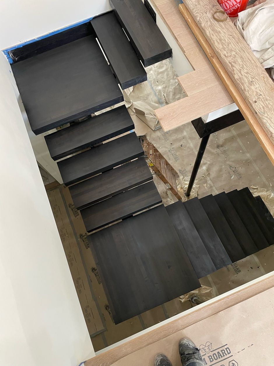 A black staircase is being built in a house.