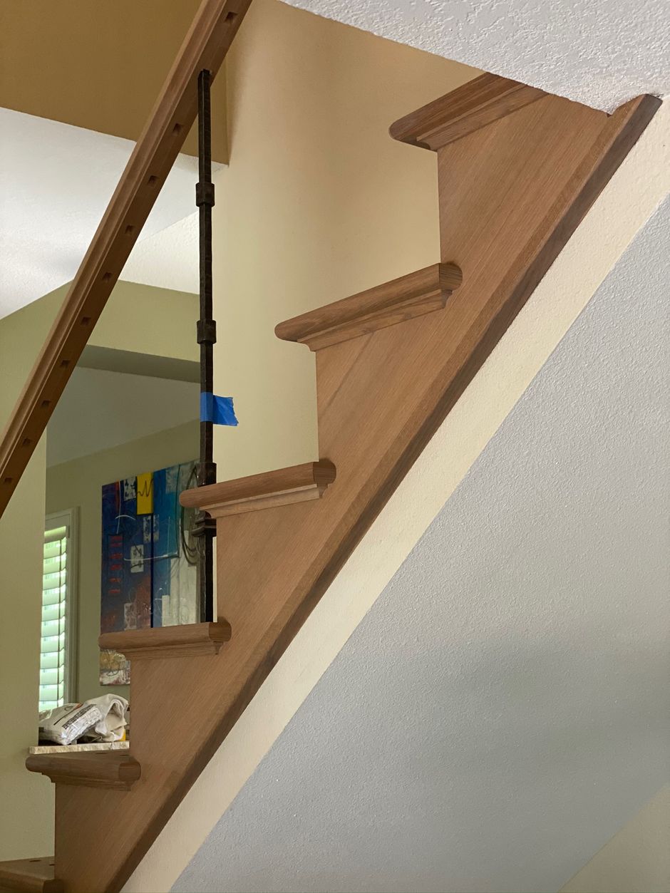 A wooden staircase with a glass railing in a house