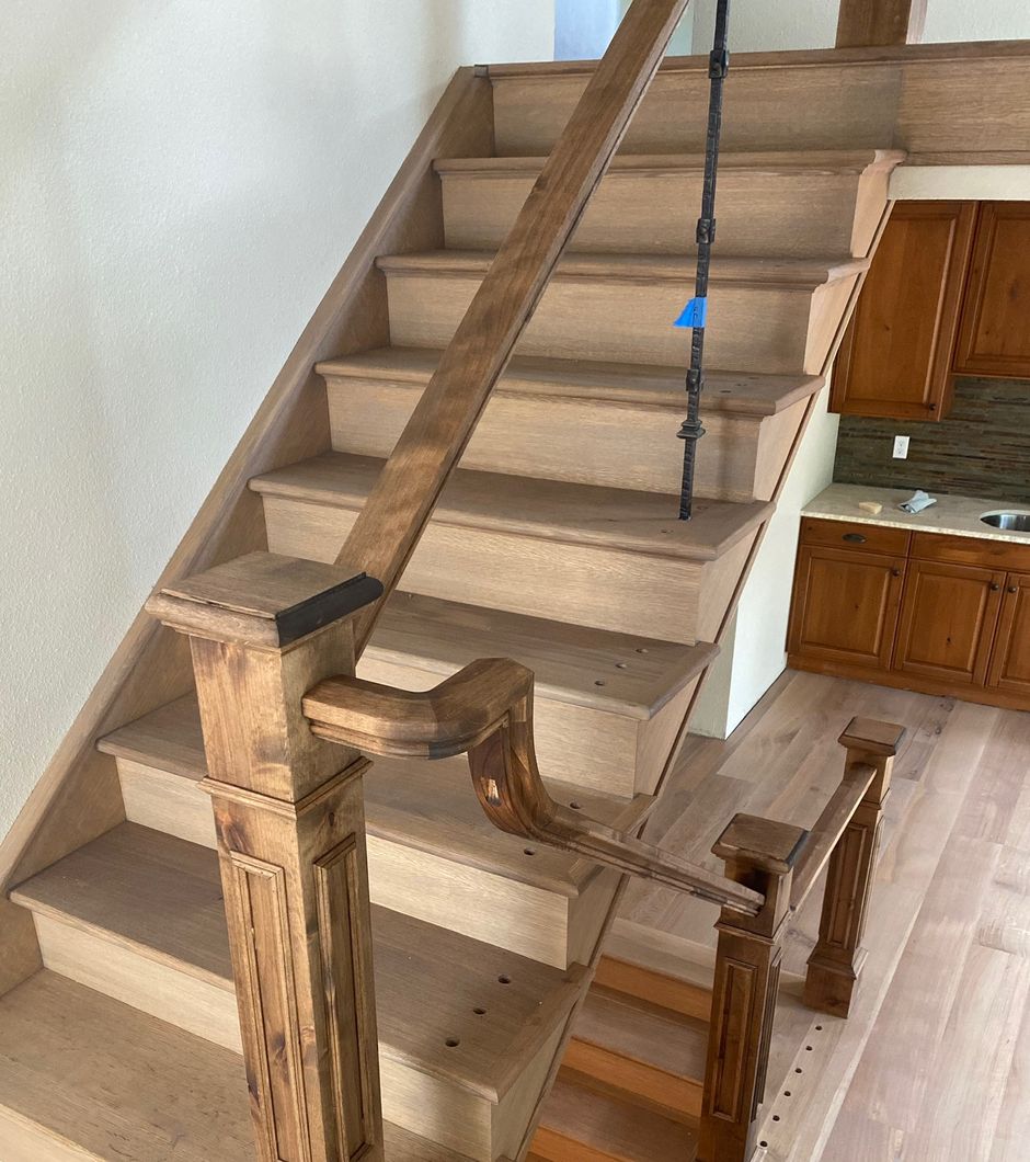 A wooden staircase with a metal railing in a kitchen