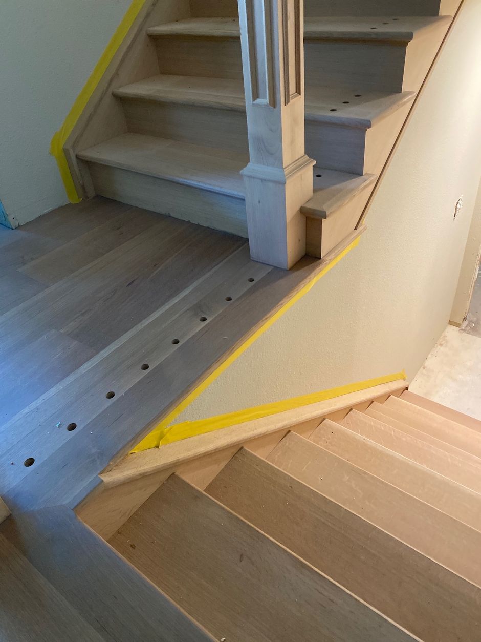 A wooden staircase with a yellow stripe on the side