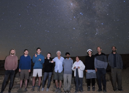 A group of people standing in front of a starry sky