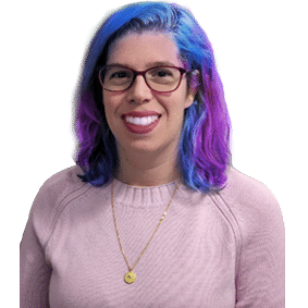 A woman with blue and purple hair is wearing glasses and a pink sweater.
