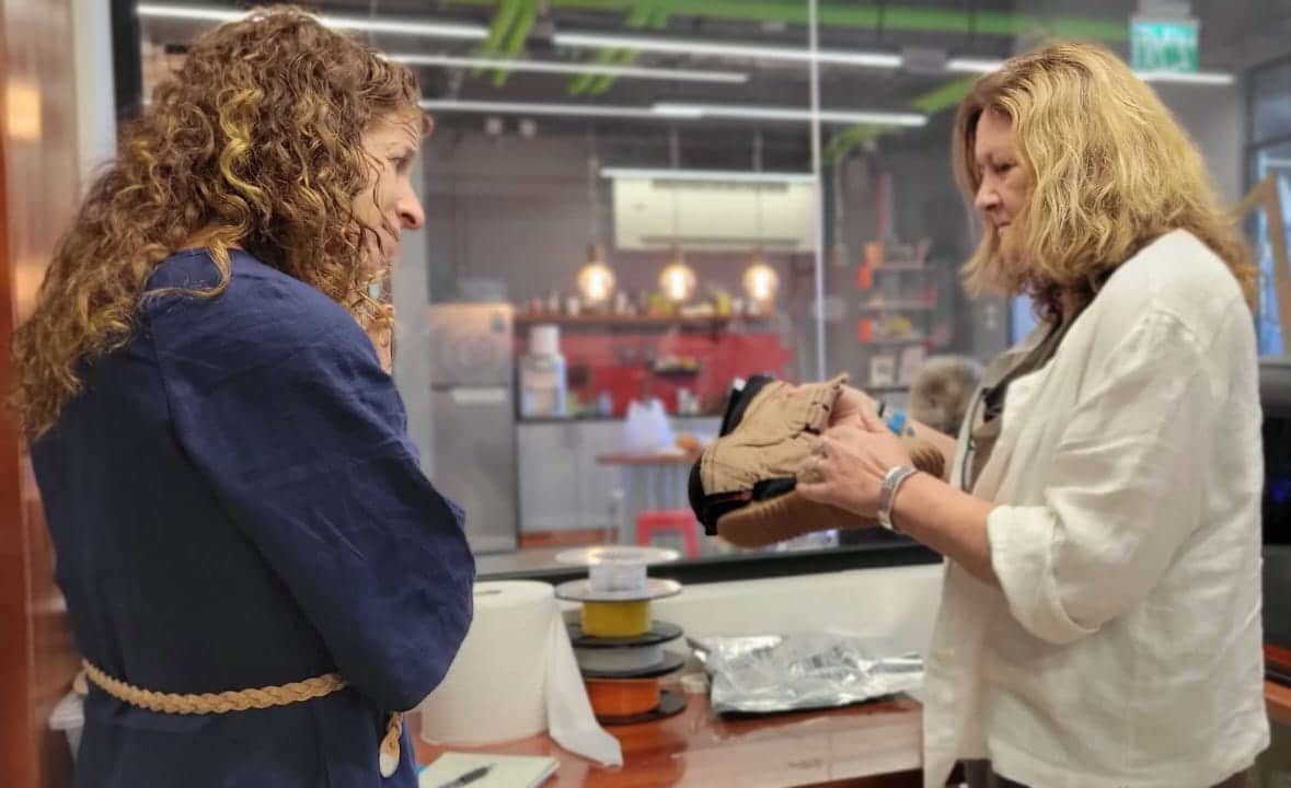 Two women are standing next to each other in a room.