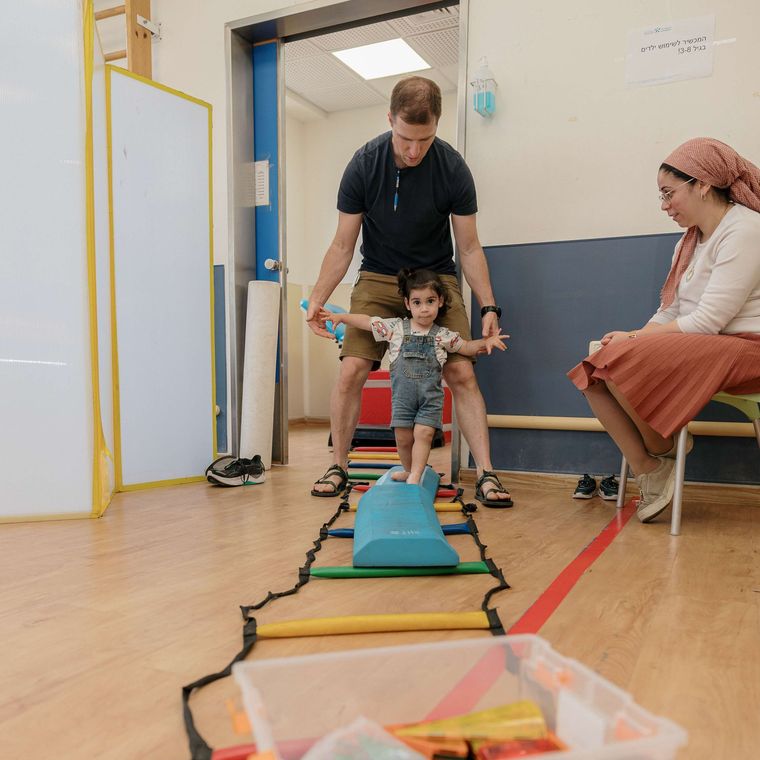 A man and a woman are playing with a little girl