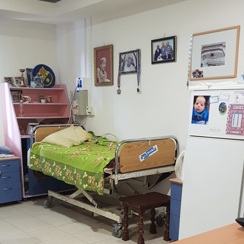 A hospital room with a bed and a refrigerator with a picture of a baby on it