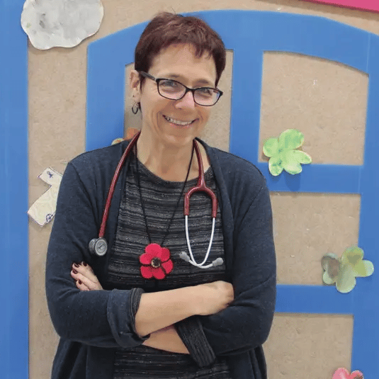 A woman wearing glasses and a stethoscope around her neck