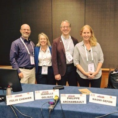 A group of people standing around a table with name tags that say felix chenier and naomi geten