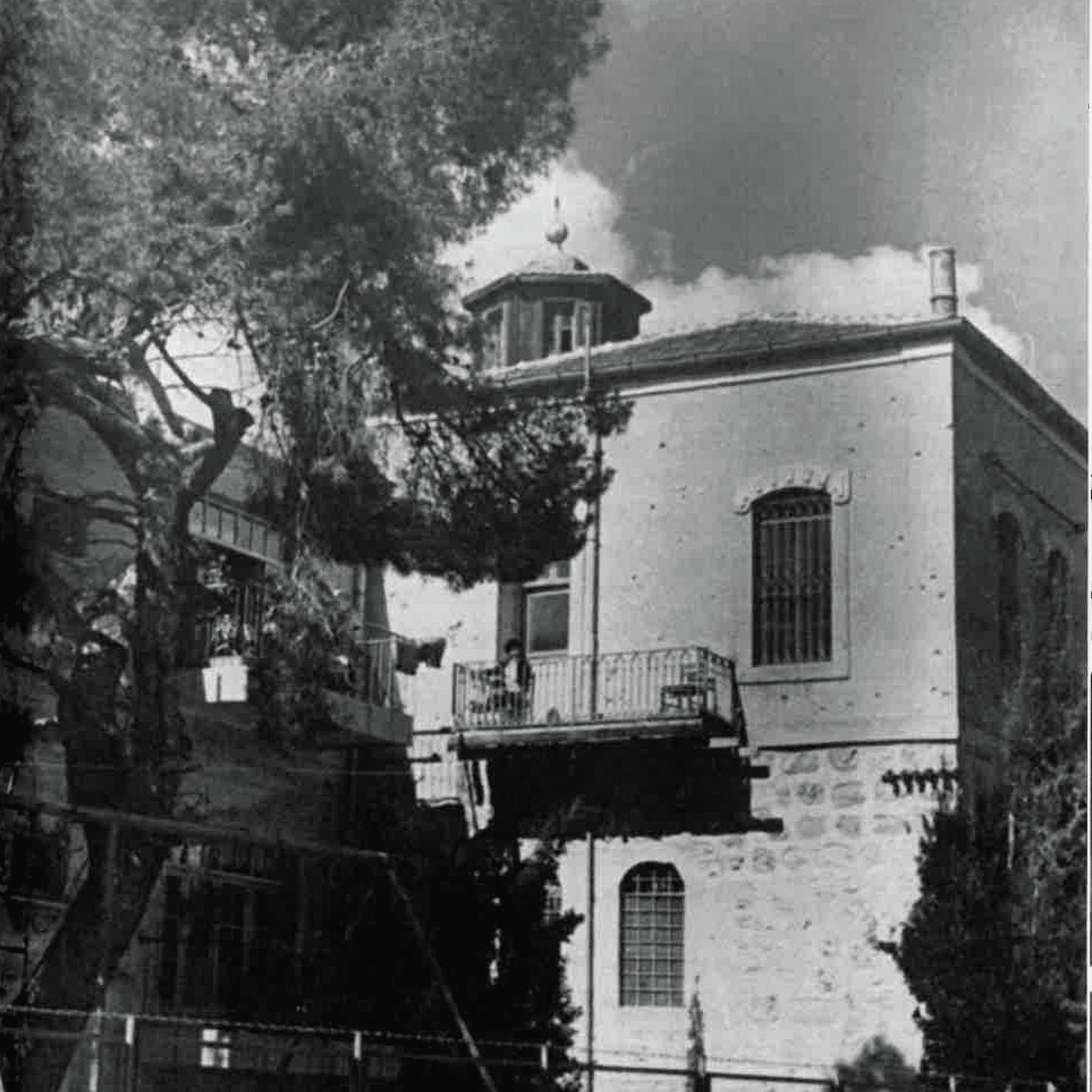 A black and white photo of a house with a balcony