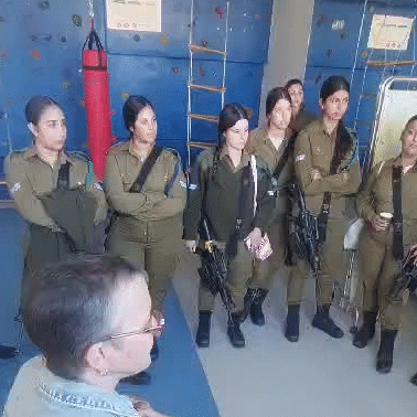 A group of soldiers are standing around a man in a room.