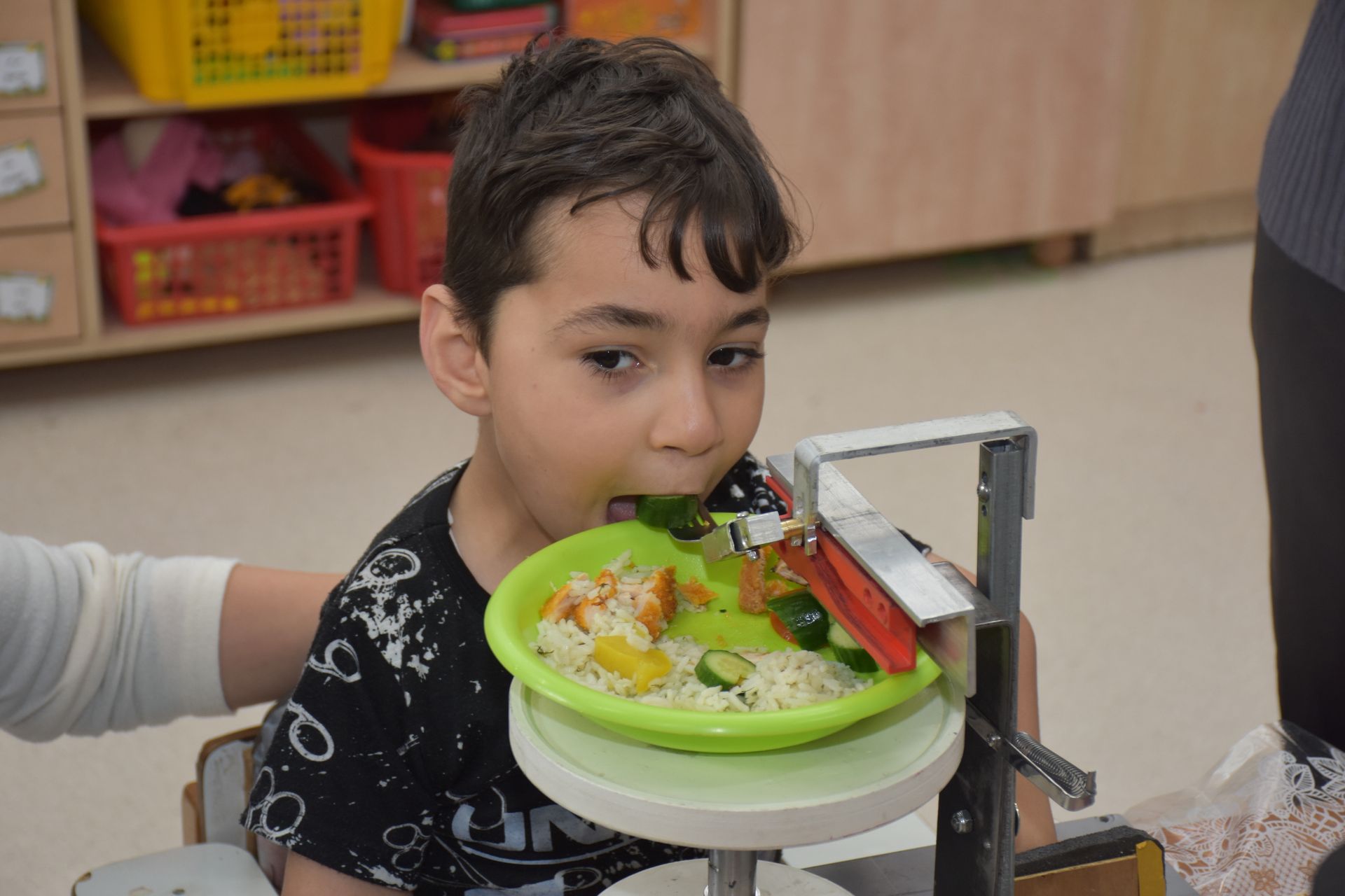 A young boy is eating food from a green plate.