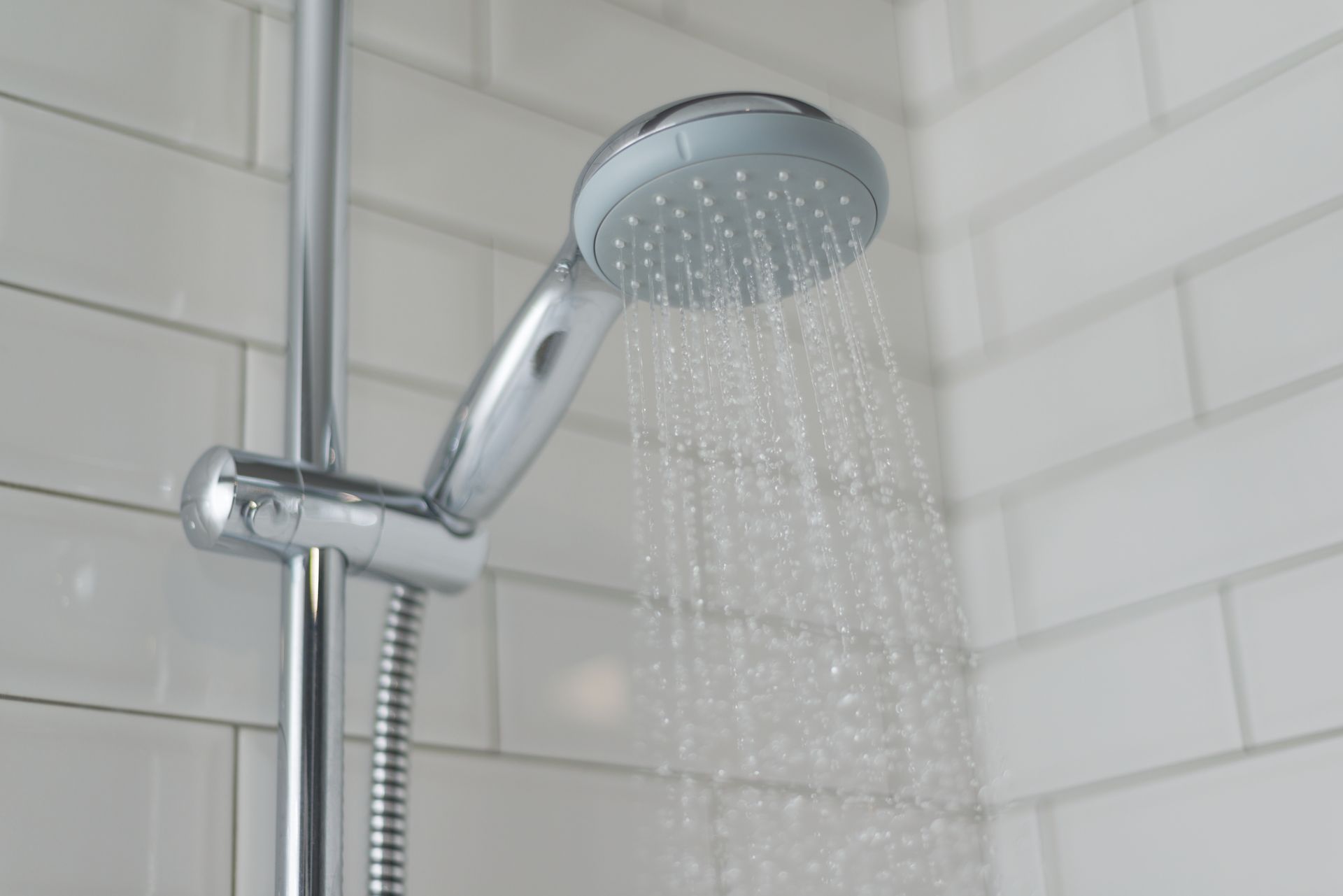 a close up of a shower head in a bathroom with water coming out of it .