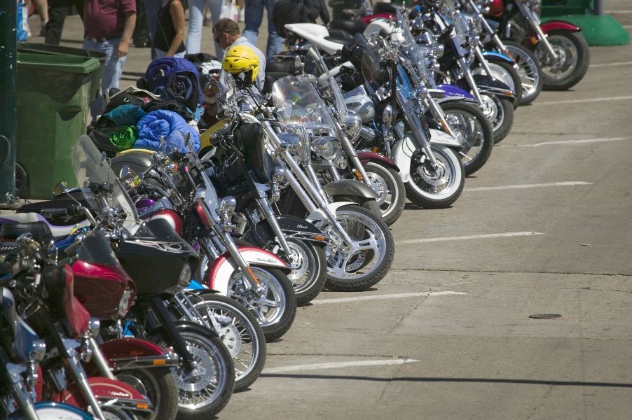 a row of motorcycles are parked in a parking lot