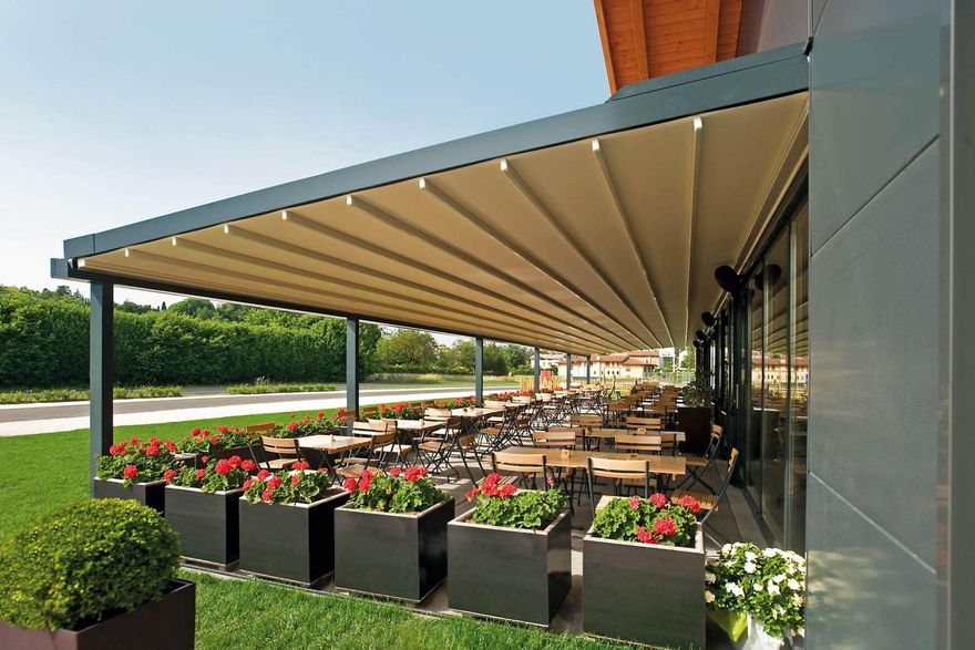 A restaurant with tables and chairs under a canopy