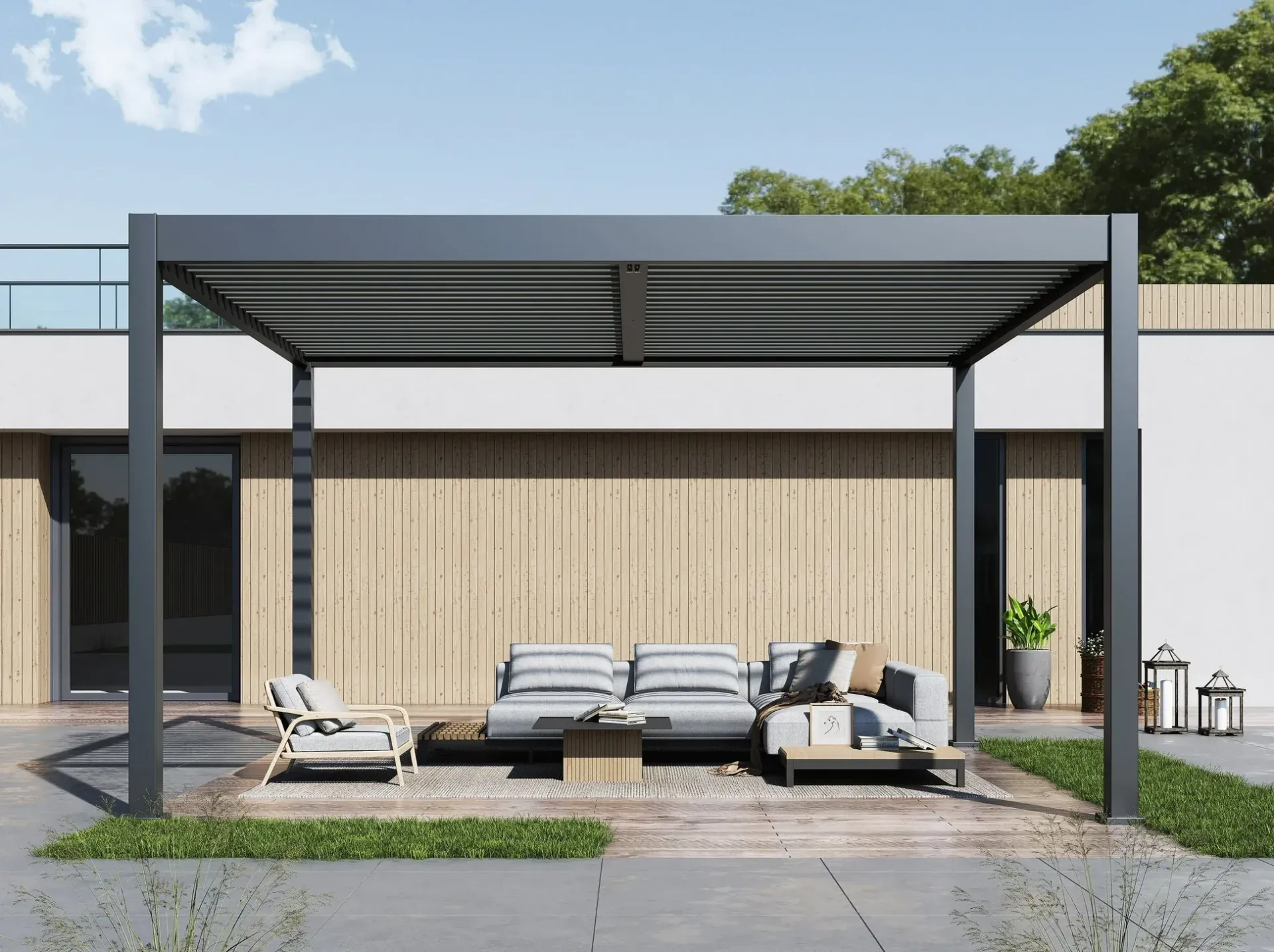 A pergola with a couch and chairs underneath it in front of a house.