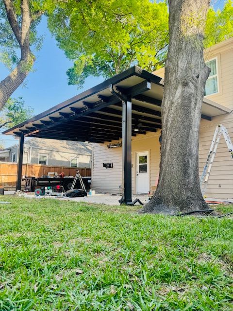 A covered patio is being built in the backyard of a house.