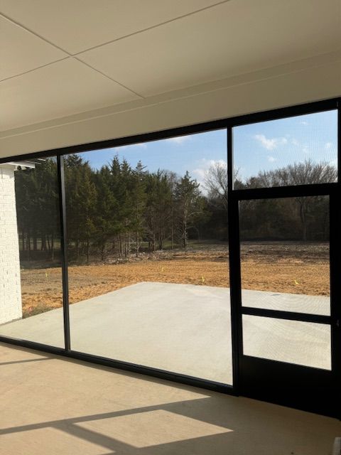 A large window with a view of a field and trees