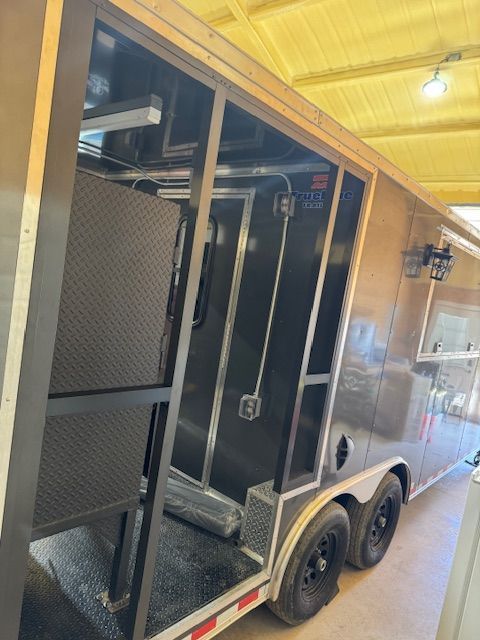 A trailer is parked in a garage with the door open