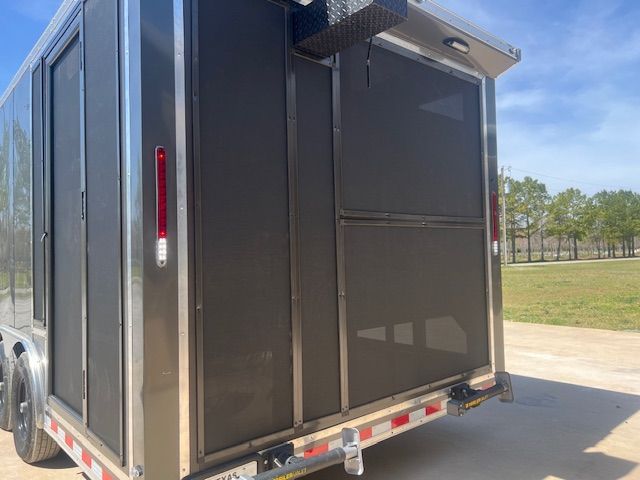A trailer with a screen door is parked on the side of the road.