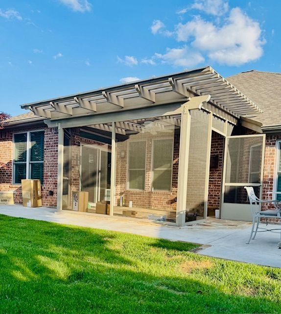 A brick house with a screened in porch and a pergola