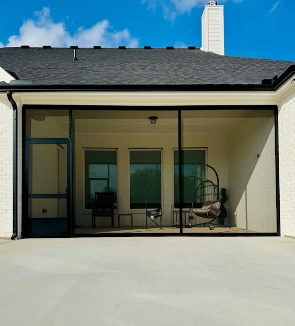 A house with a screened in porch with chairs and tables