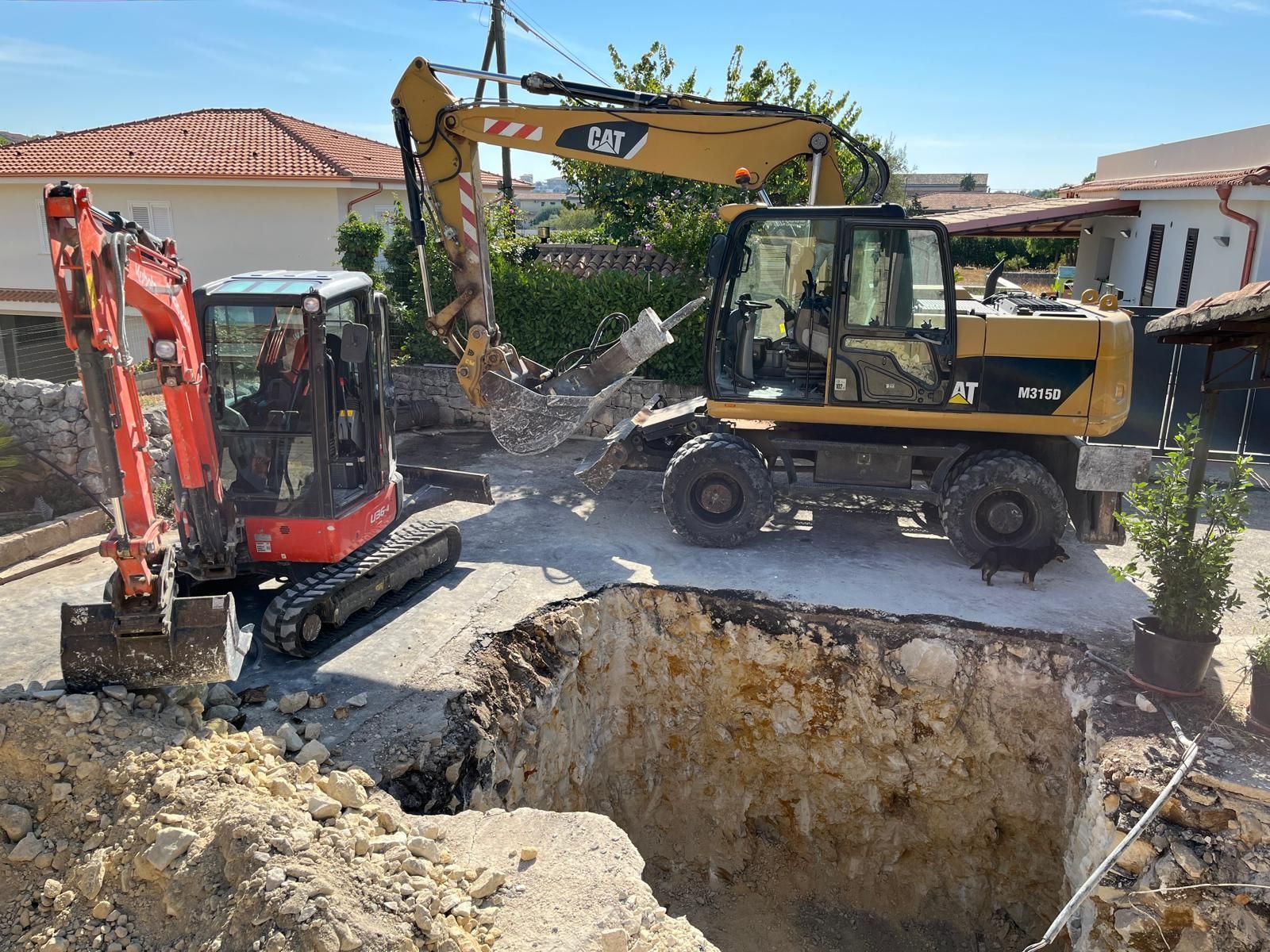Due escavatori gialli stanno demolendo un edificio.