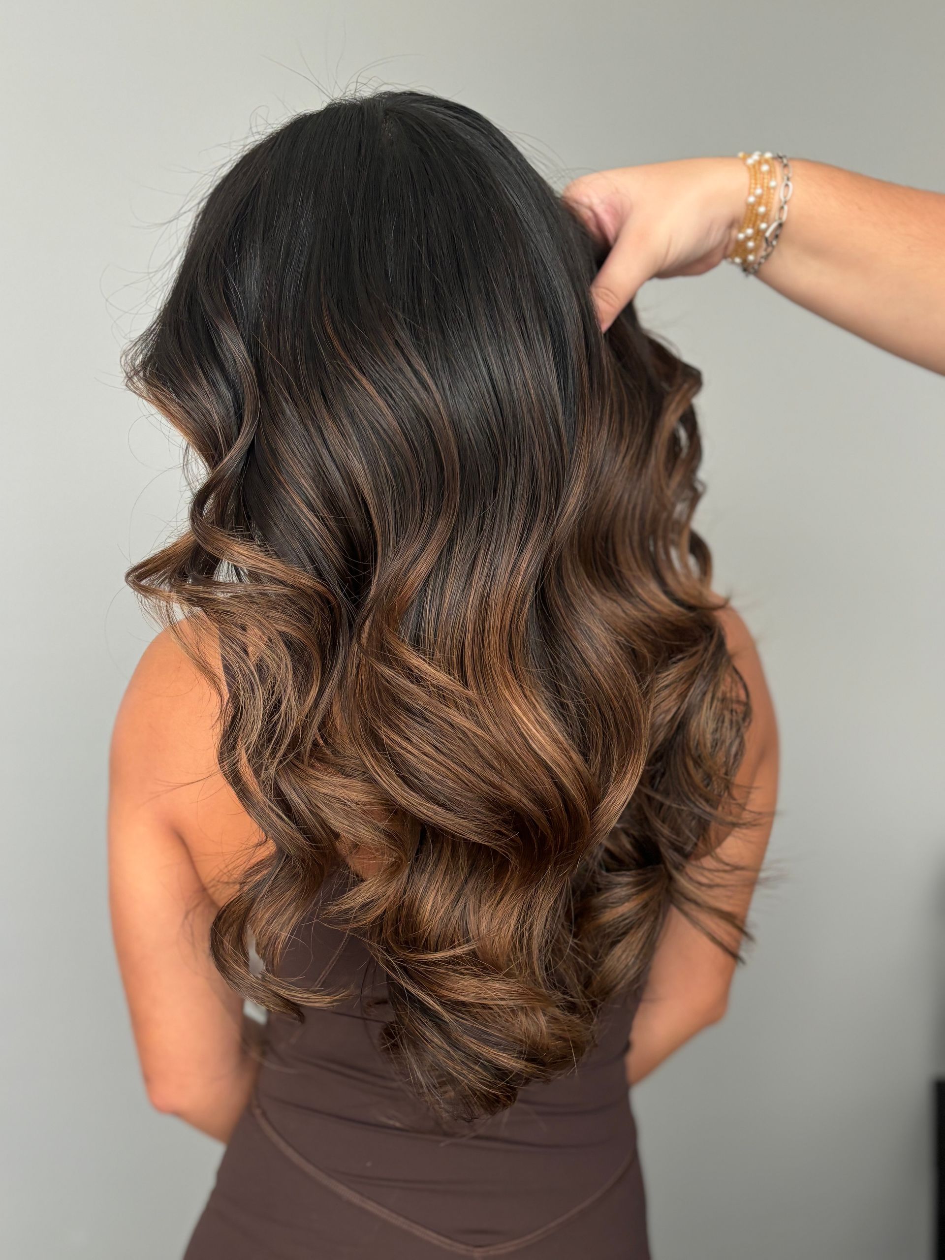 A woman is getting her hair done by a hairdresser.
