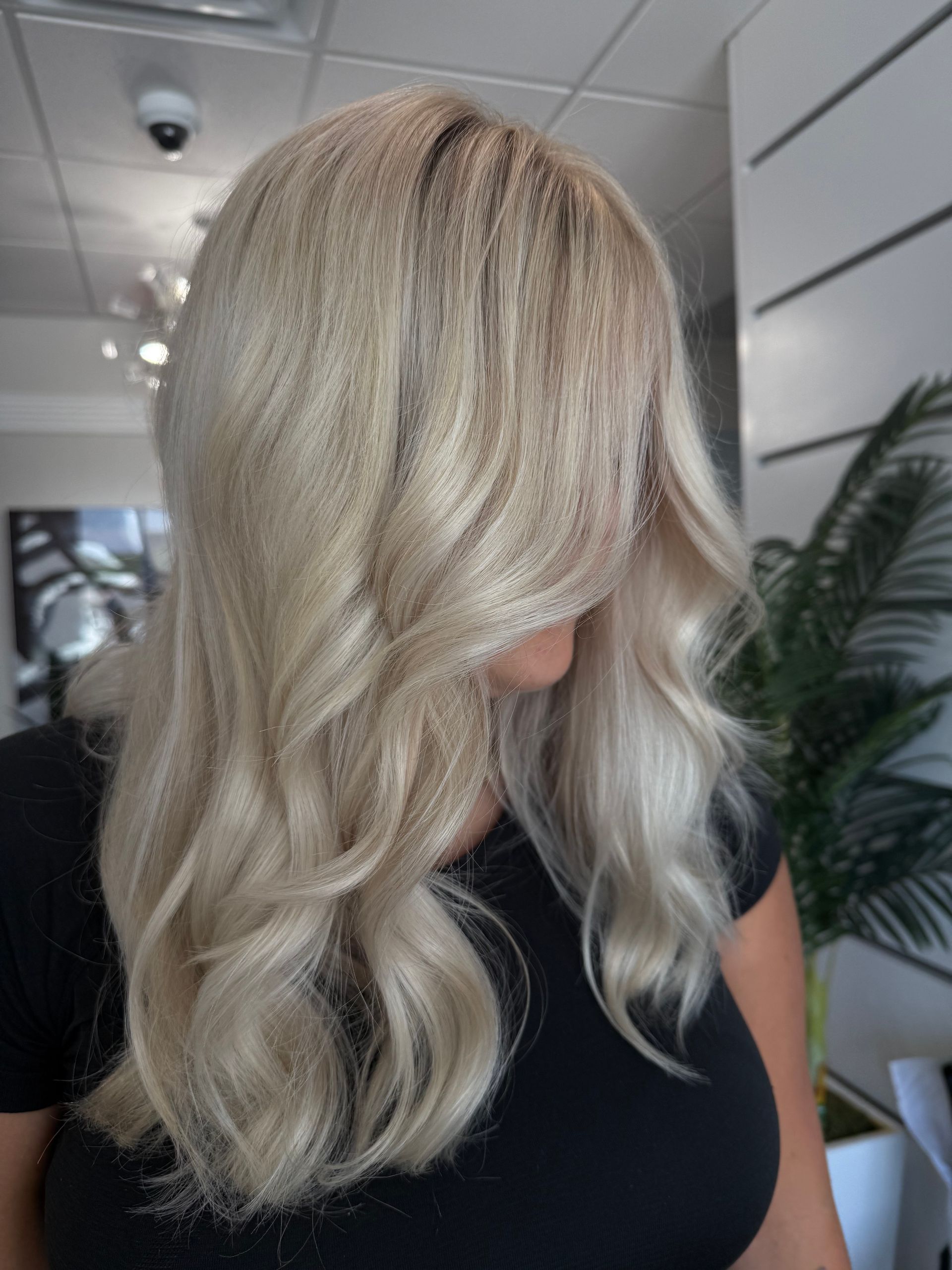 A woman with long blonde hair is wearing a leopard print top.