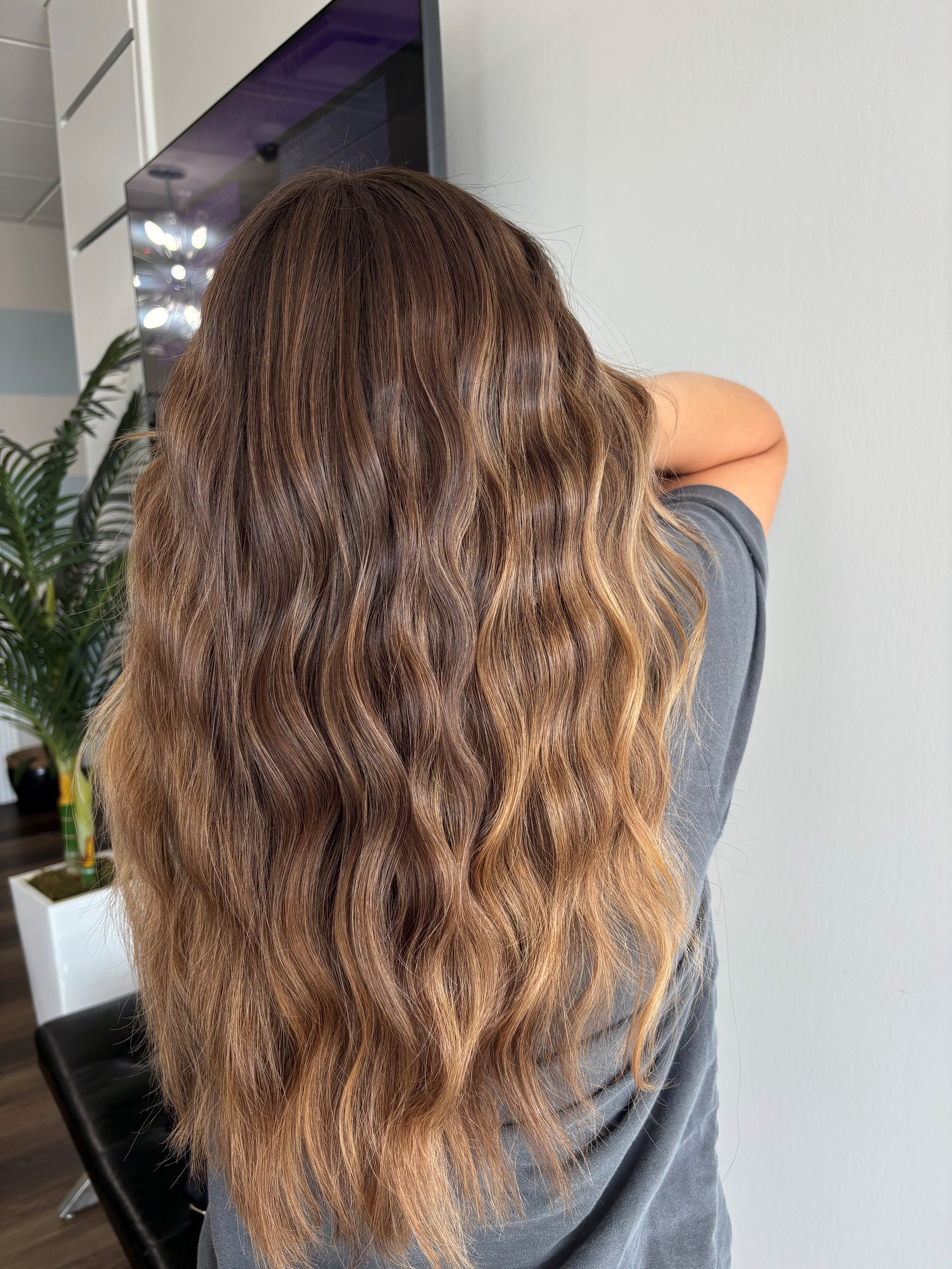 A woman with long blonde hair is wearing a leopard print top.