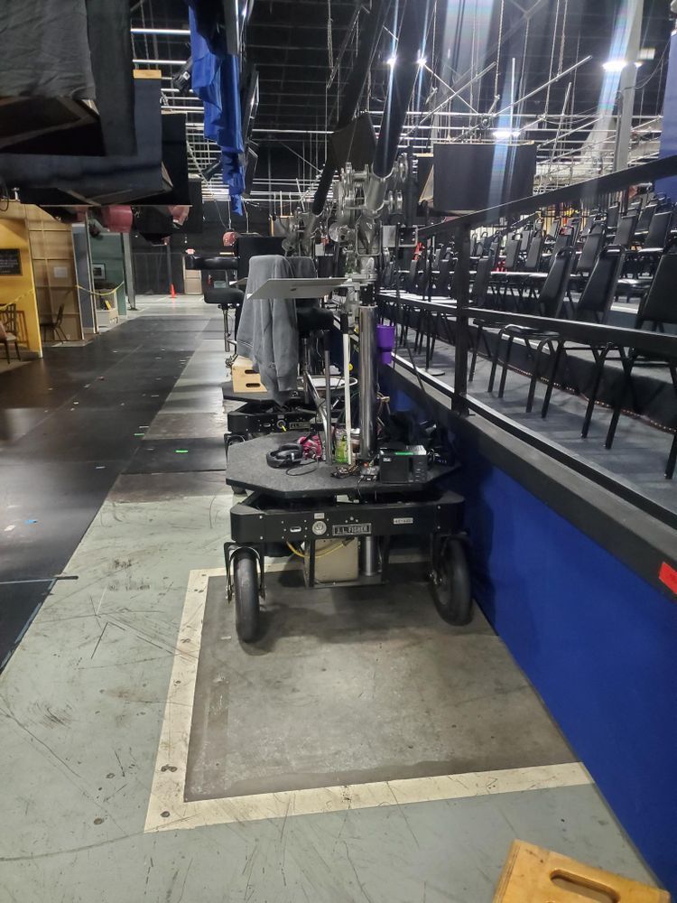 A row of chairs are lined up in an empty auditorium