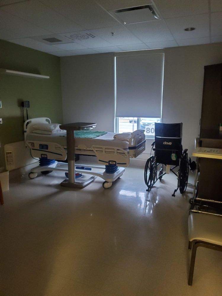 A hospital room with a bed and a wheelchair