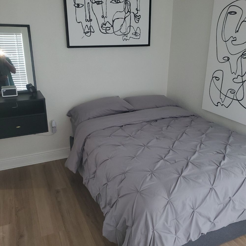A bedroom with a bed and a painting on the wall