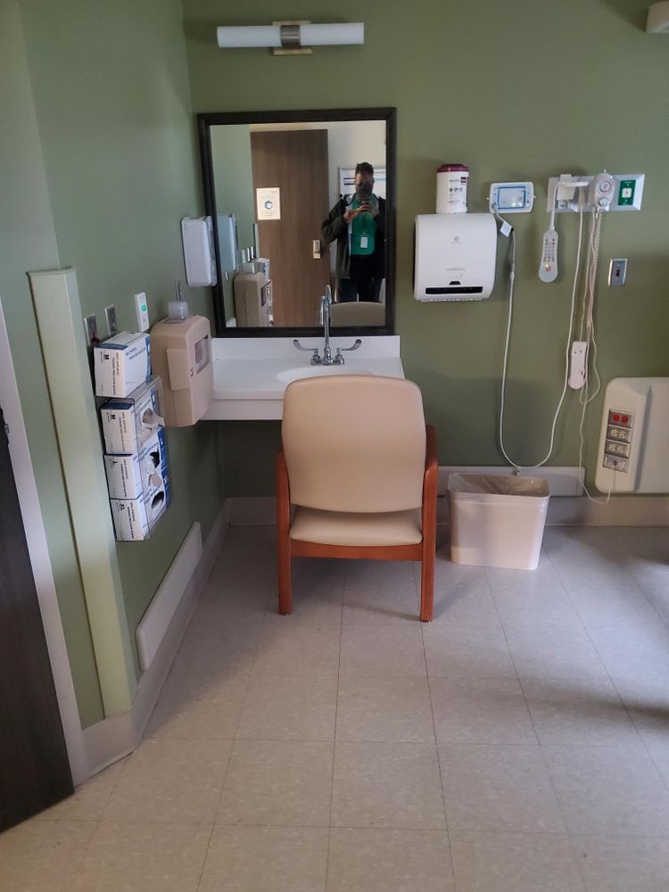 A bathroom with a chair a sink and a mirror